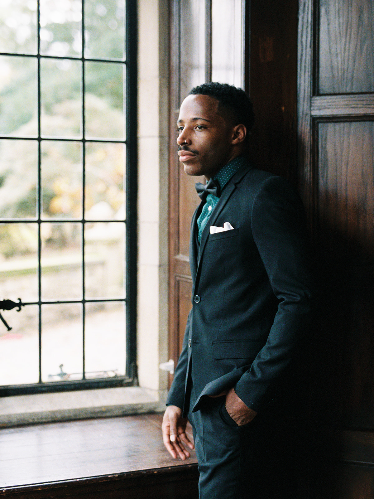 Elegant man in a suit looks thoughtfully out of a window