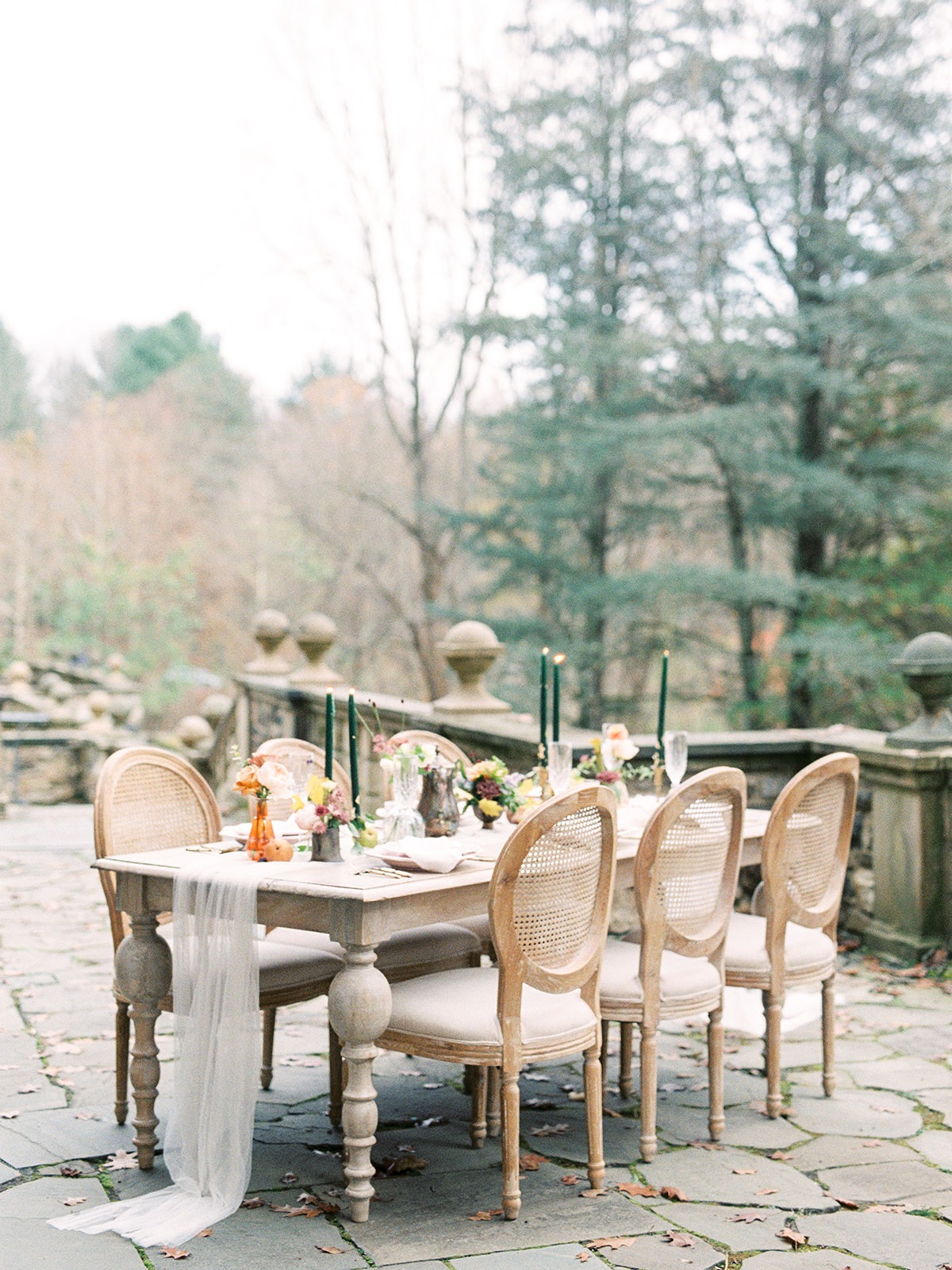 Elegant outdoor dining table setting with flowers and candles