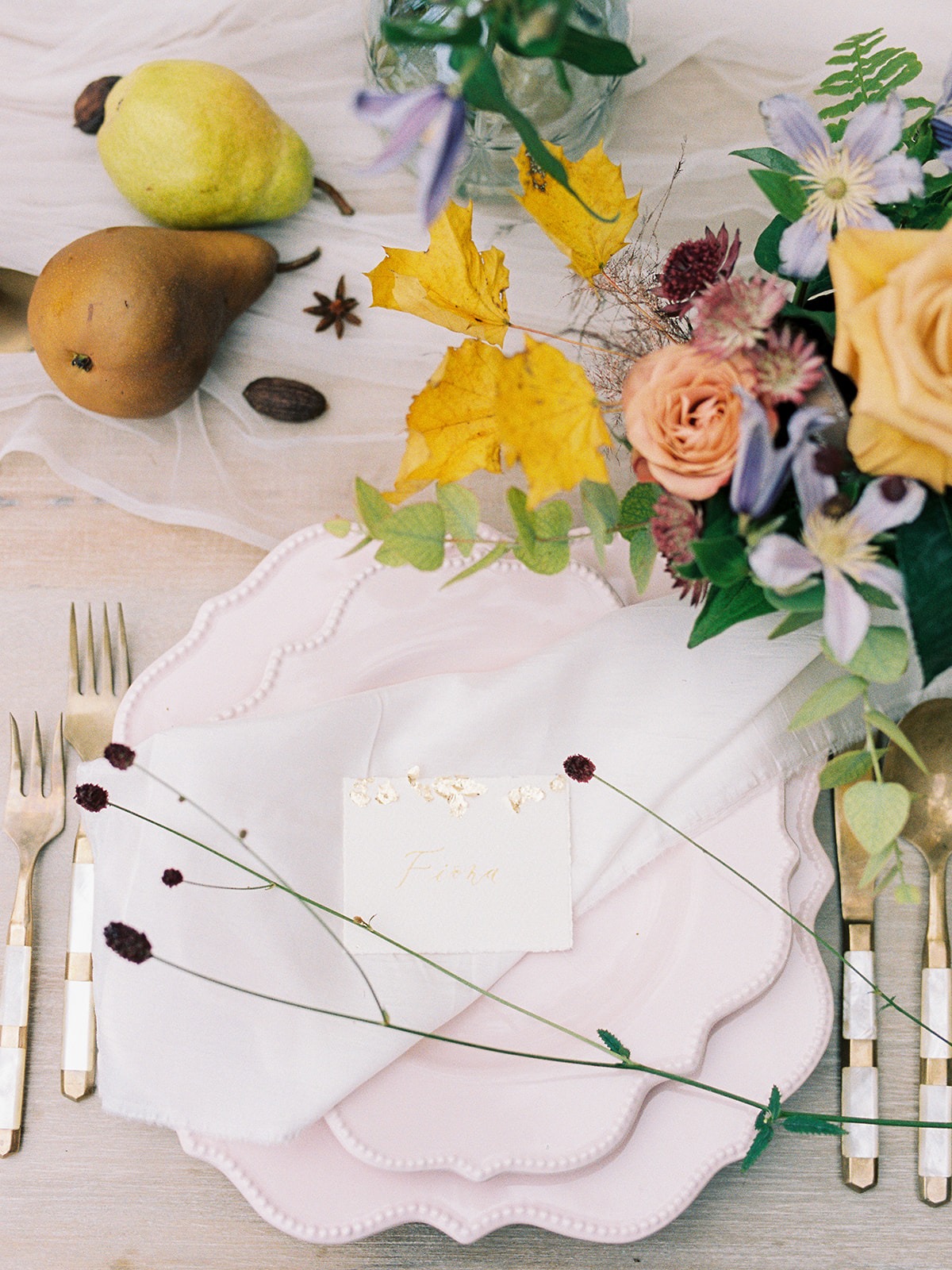 Elegant place setting with pears and floral arrangement for a wedding