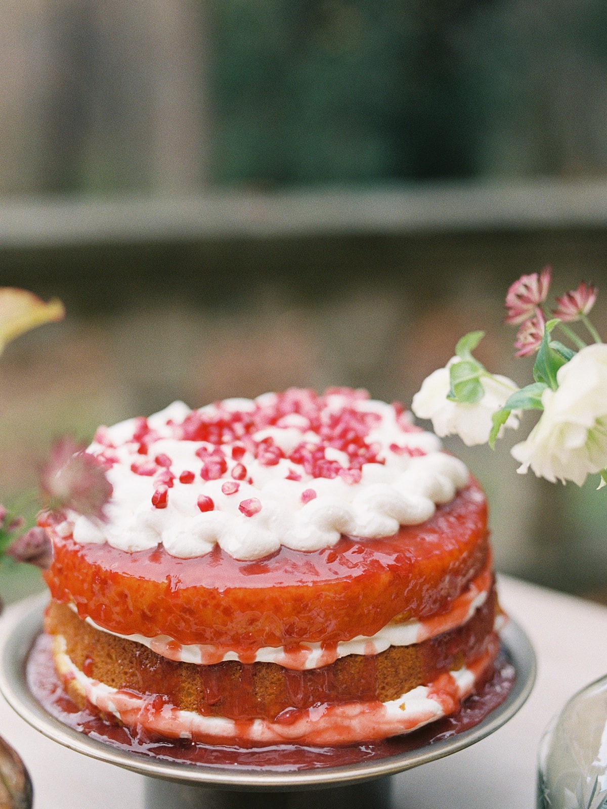 Delicious layered cake with red glaze and white frosting, beautifully styled