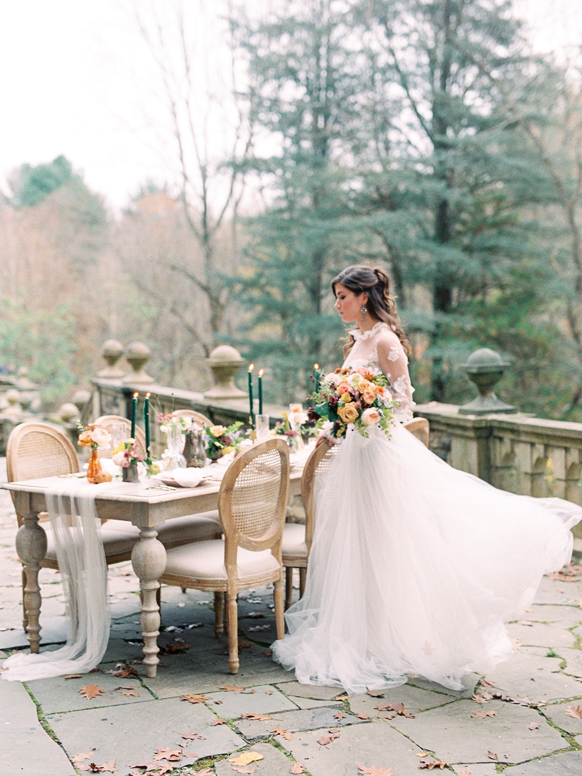 Elegant bride walks towards decorated table at outdoor wedding