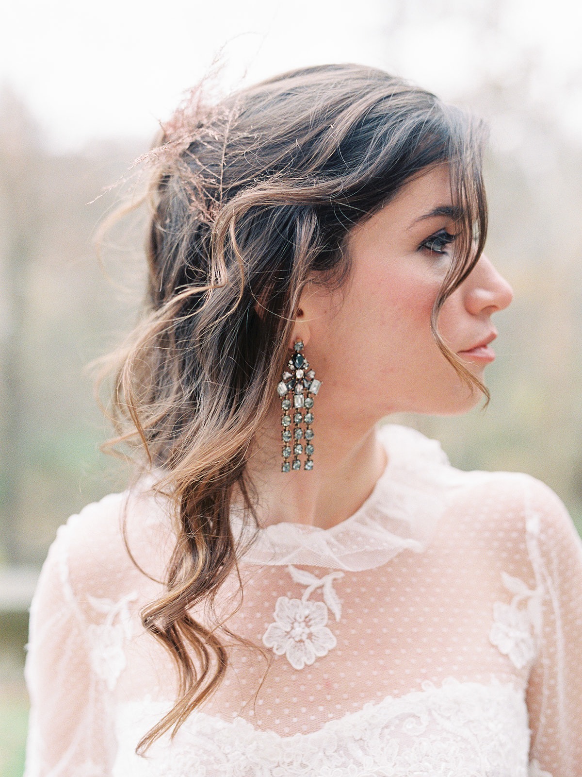 Elegant bride with earrings and floral dress looking sideways
