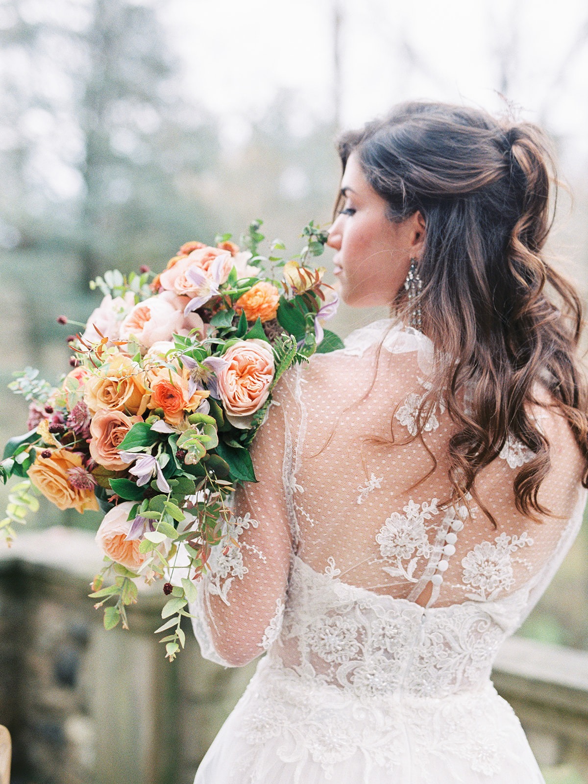 Bride with bouquet showing off her wedding dress details