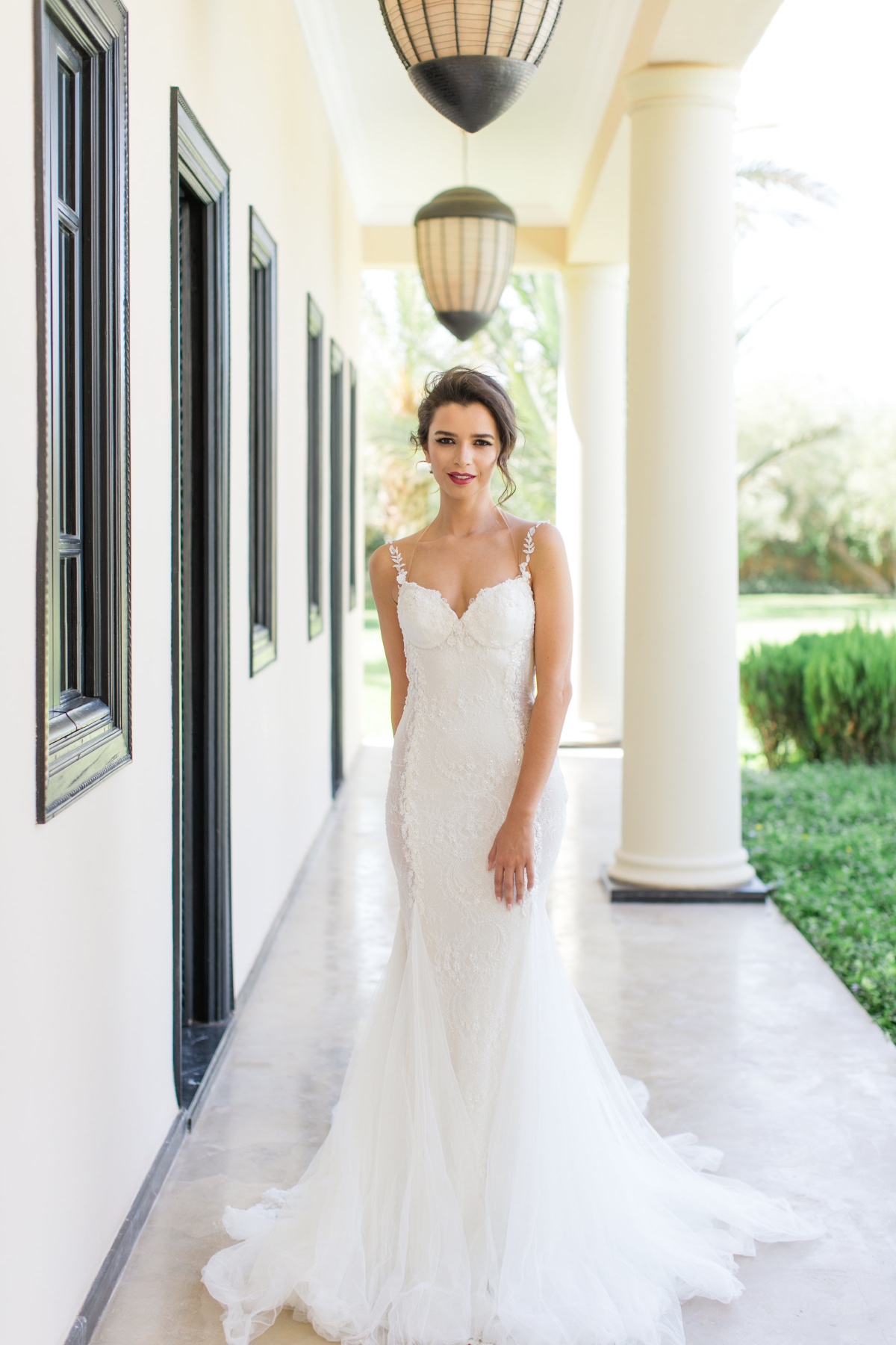 Elegant bride in a white lace wedding dress outdoors