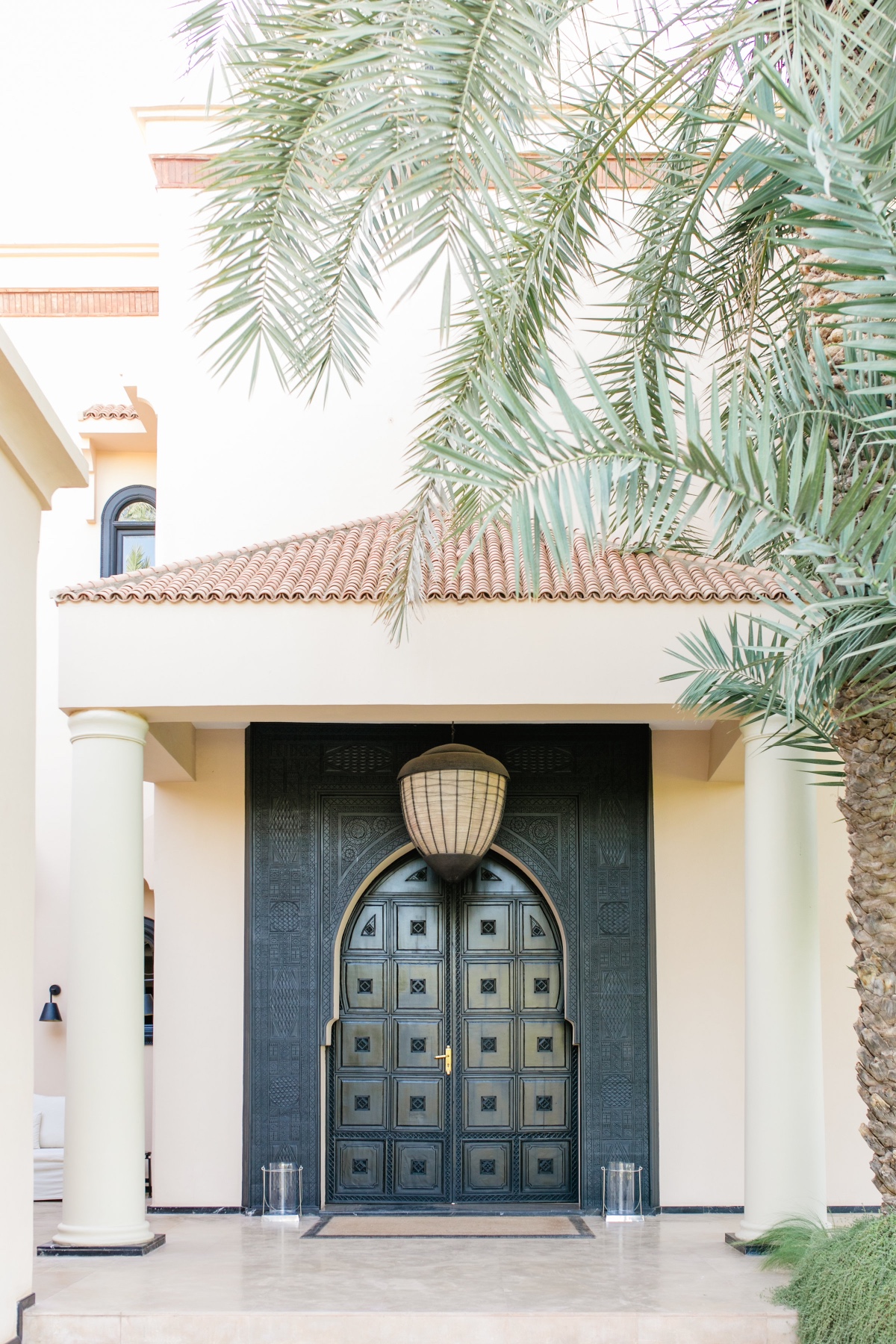 Ornate Arabic door under a palm tree on a luxury villa