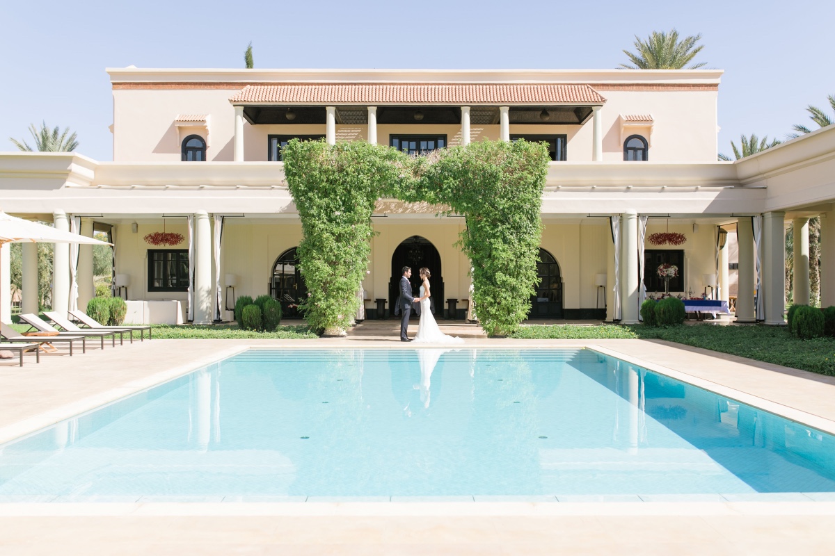 Bride and groom near pool at Moroccan villa wedding