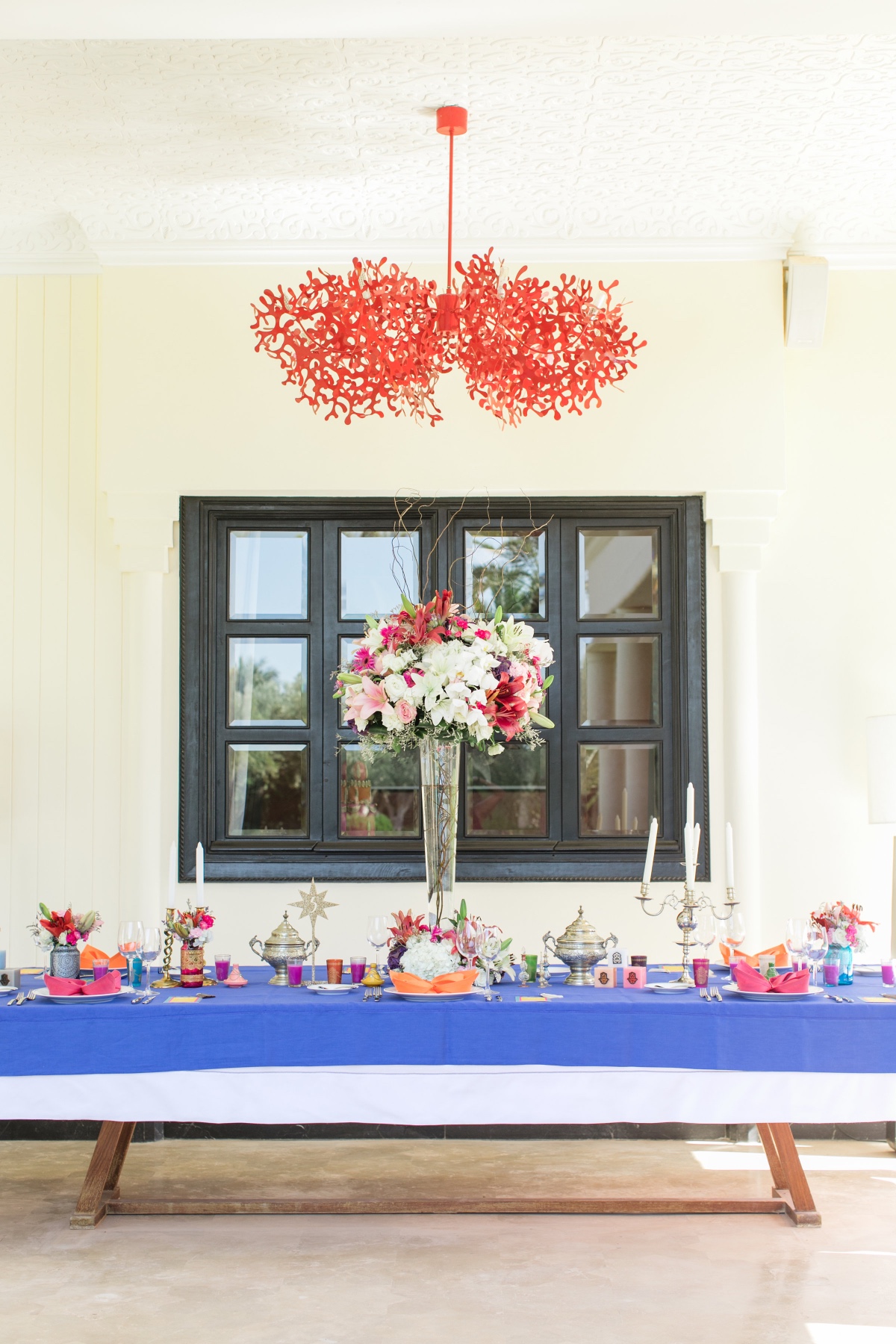 Elegantly decorated table with flowers and red chandelier