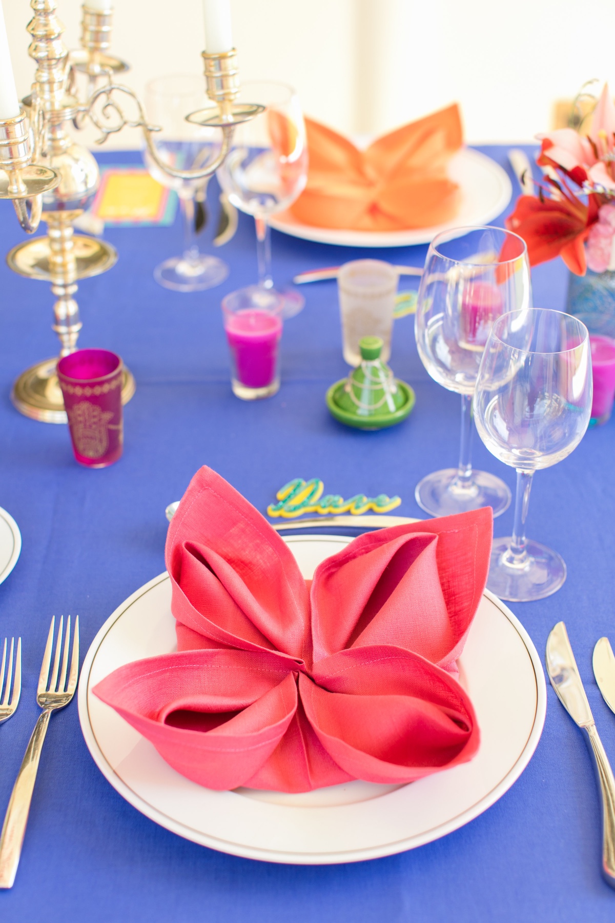Festive table setting with bright blue tablecloth and napkins