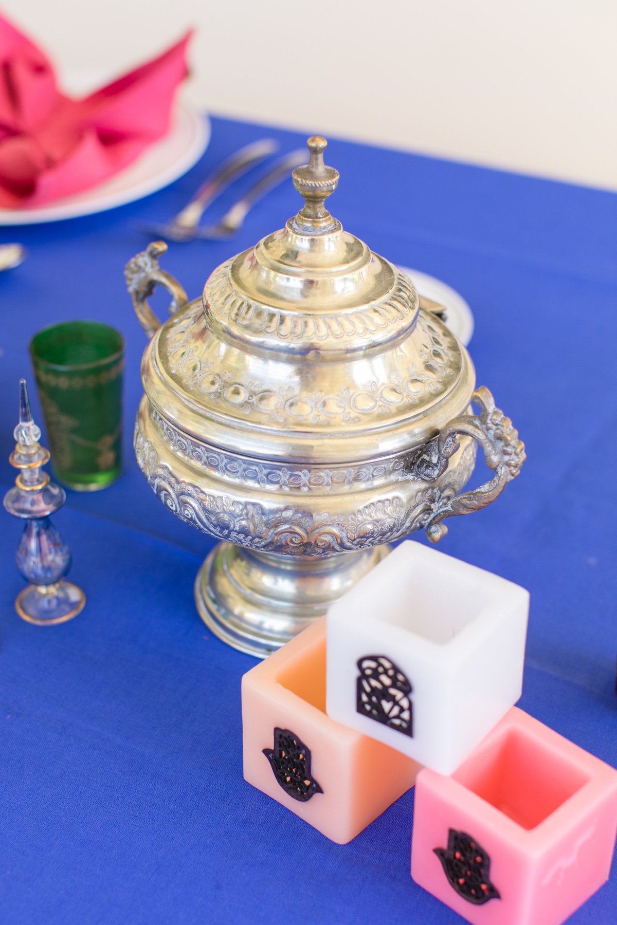 Moroccan tea service with decorative candles on blue cloth