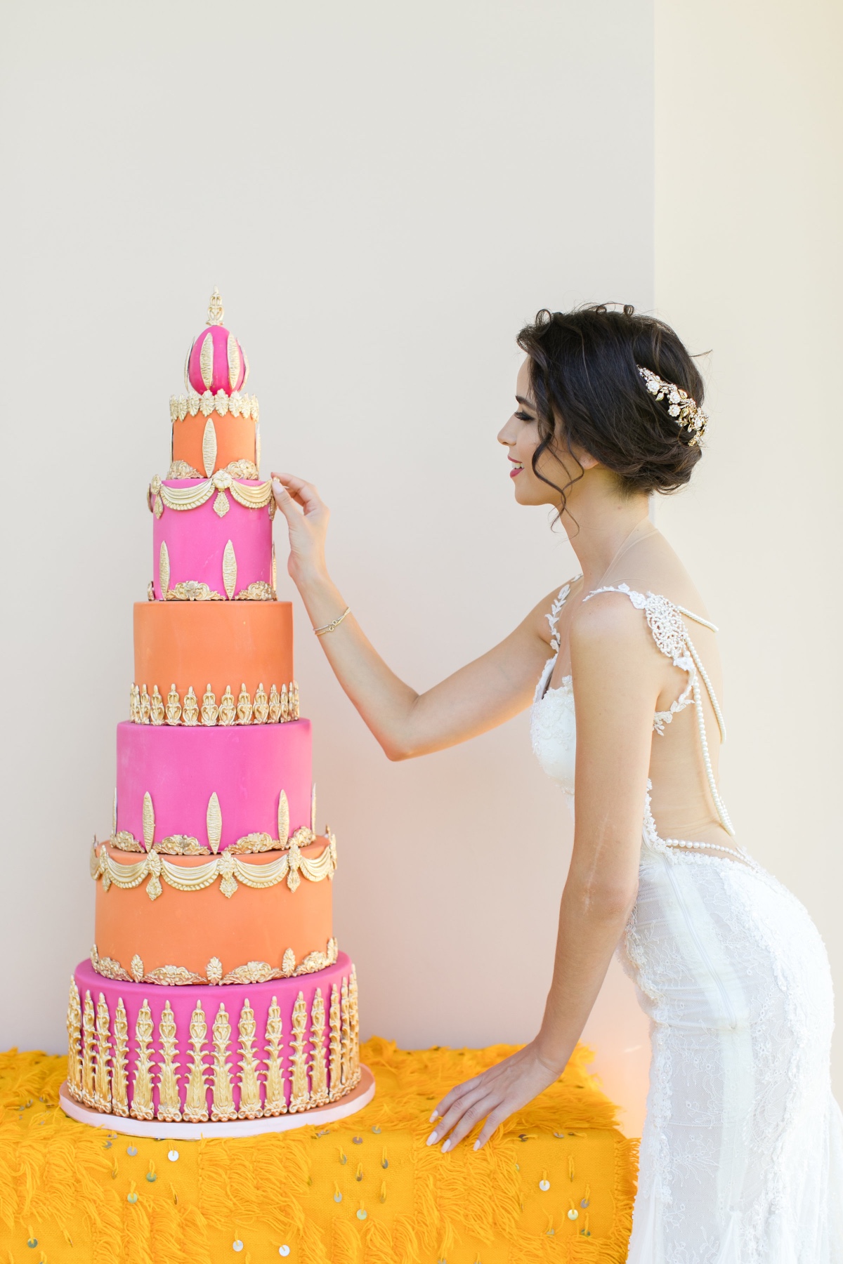 Bride admires her vibrant pink and orange wedding cake
