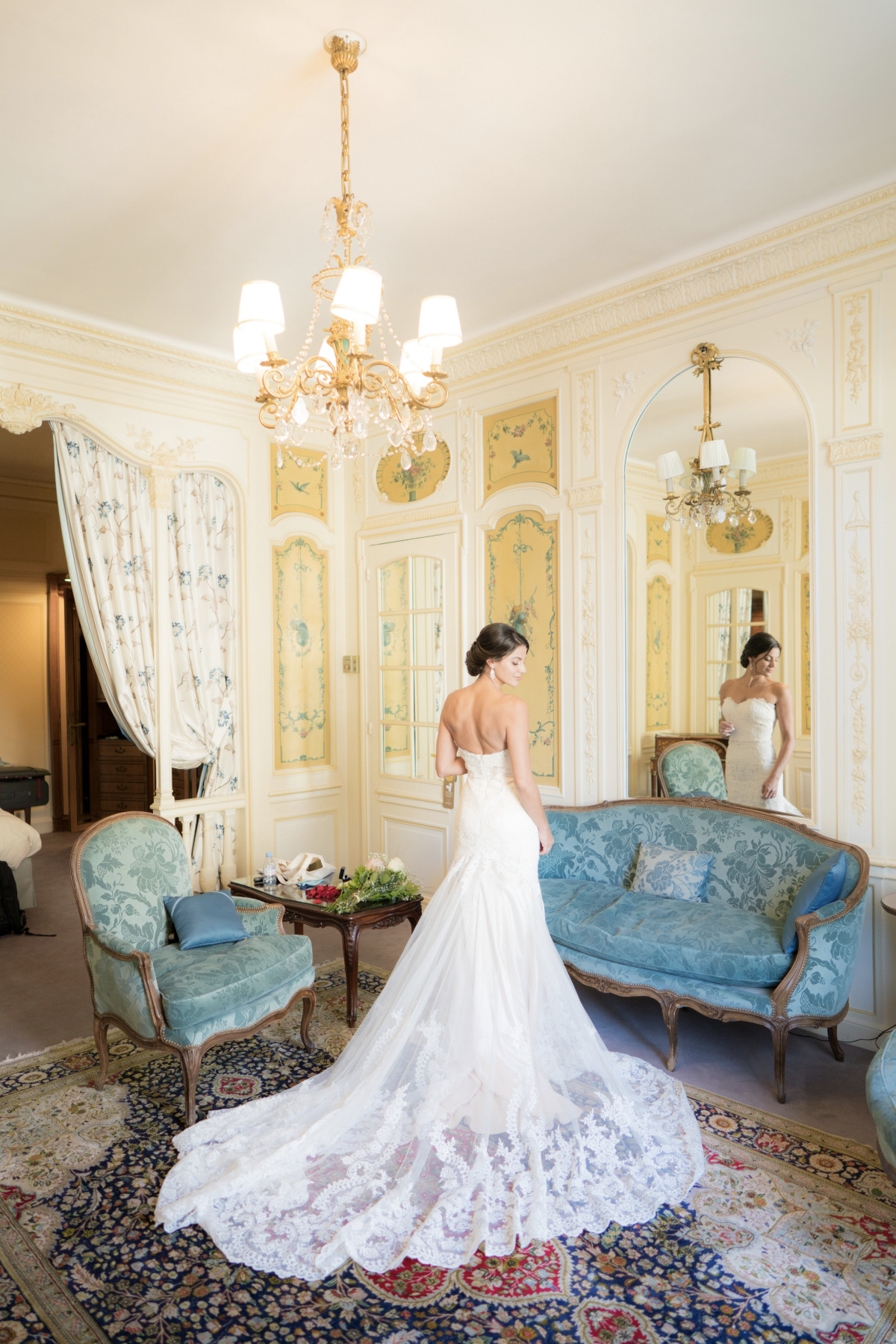 Bride in wedding dress poses in elegant bridal suite