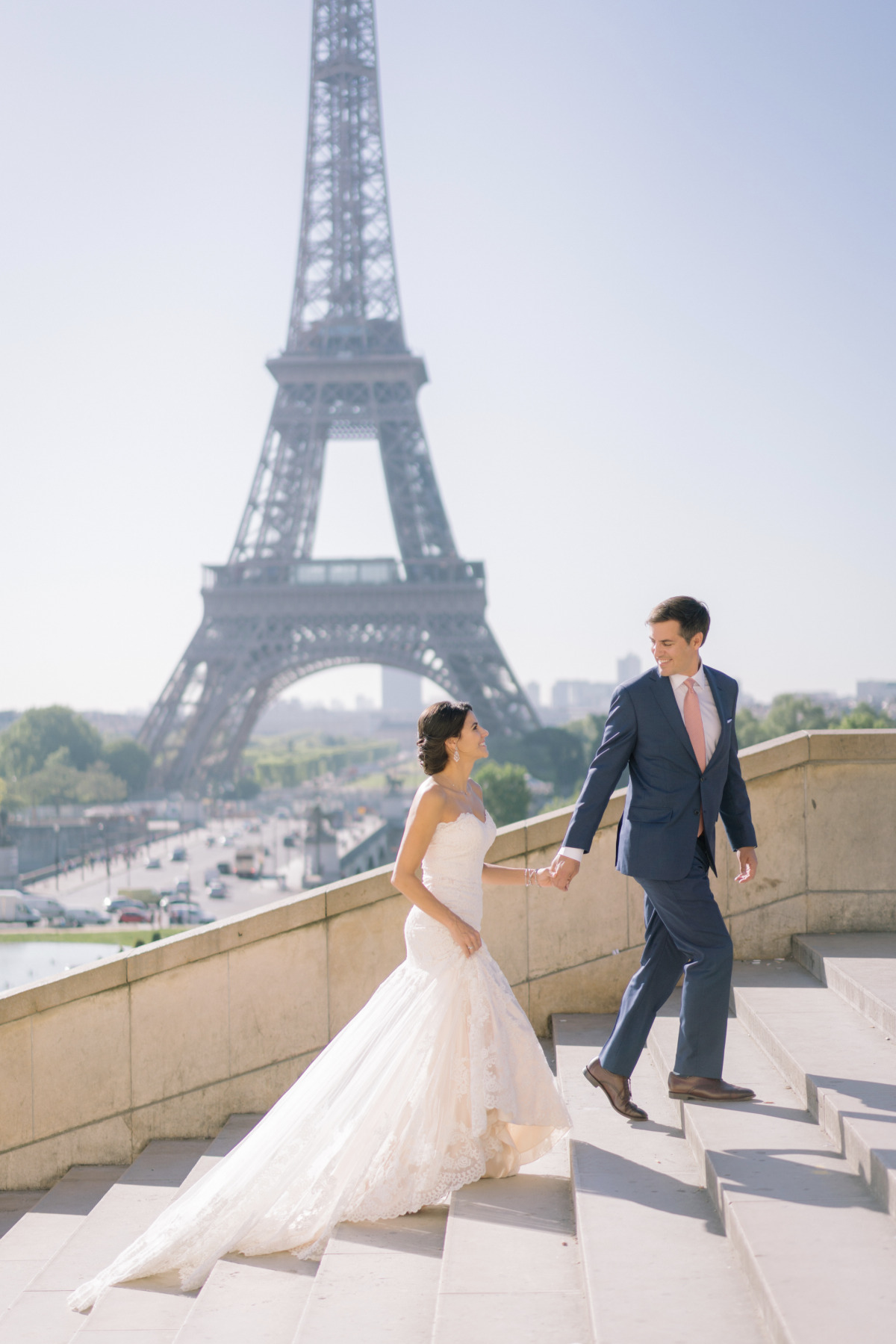 Parisian wedding couple holding hands by Eiffel Tower