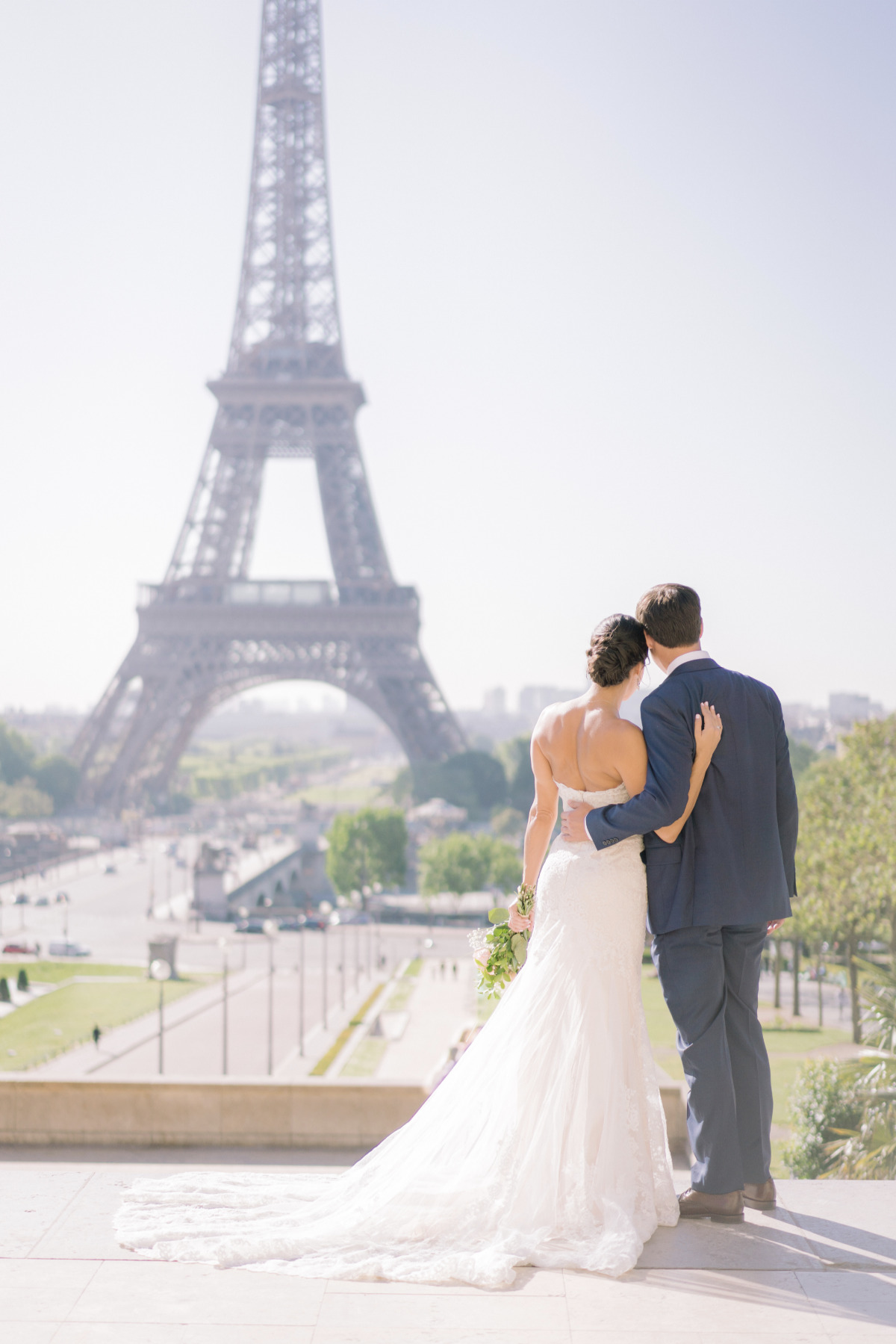 Parisian wedding: Bride and groom embrace Eiffel Tower