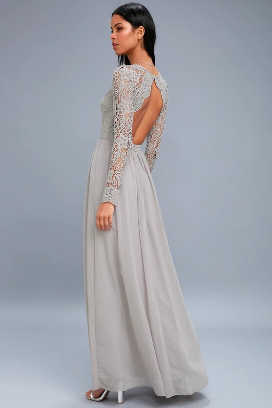 Elegant woman in gray lace-sleeved backless dress, walking gracefully