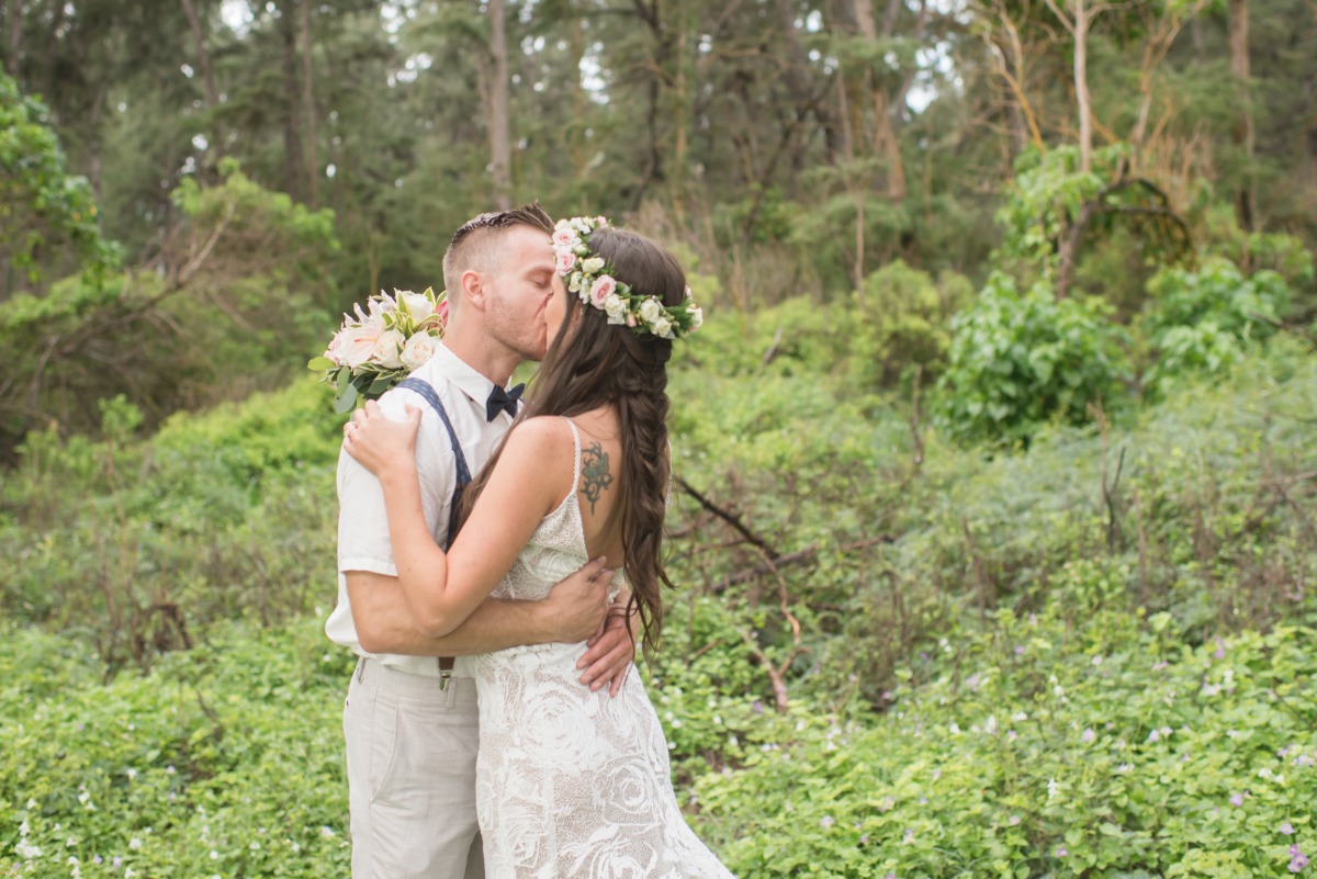 Bride and groom share a kiss outdoors at their wedding