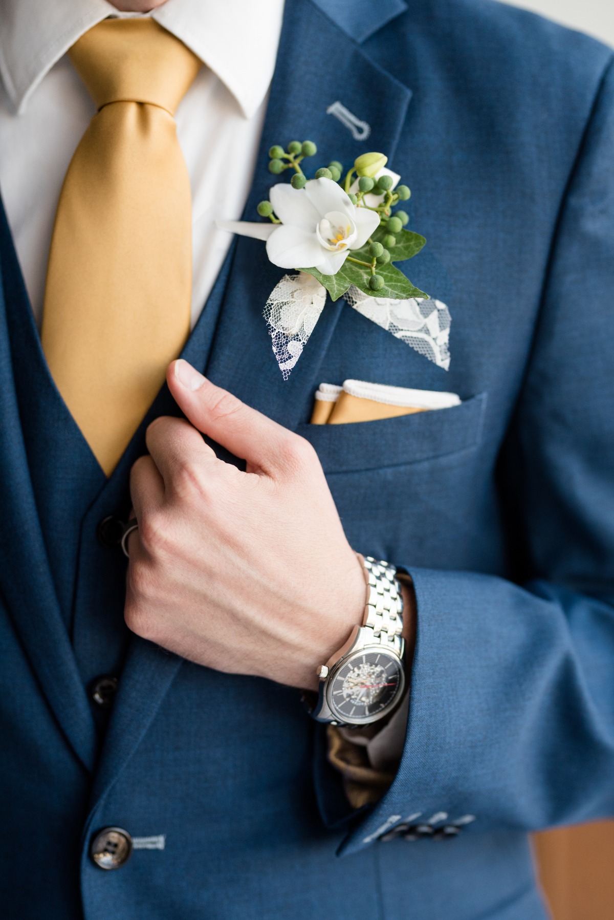 blue suit with gold tie and pocket square groom look