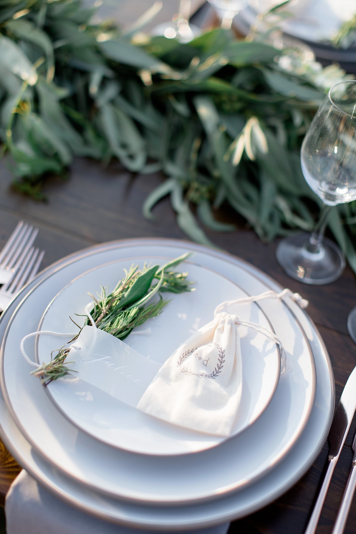 Elegant wedding place setting with rosemary and favor bag