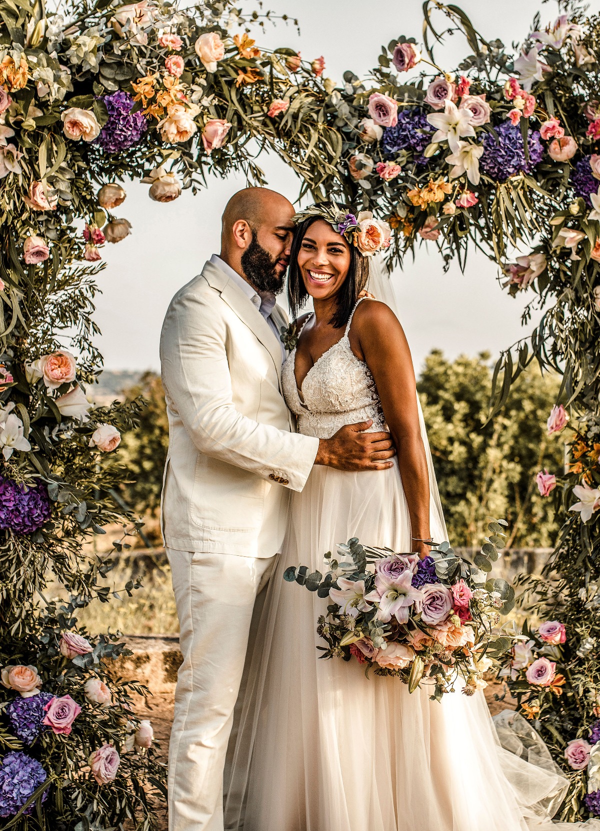 wedding couple with floral arch backdrop