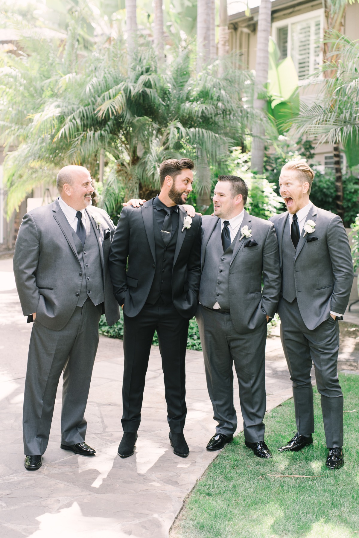 groom in all black groomsmen in grey and black