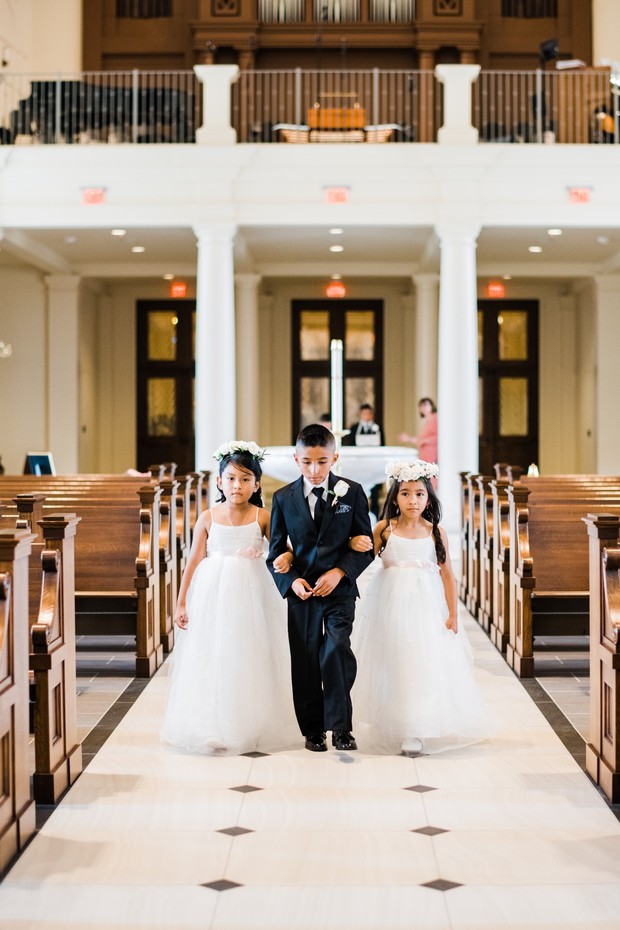 Wedding flower girls and ring bearer walking down aisle