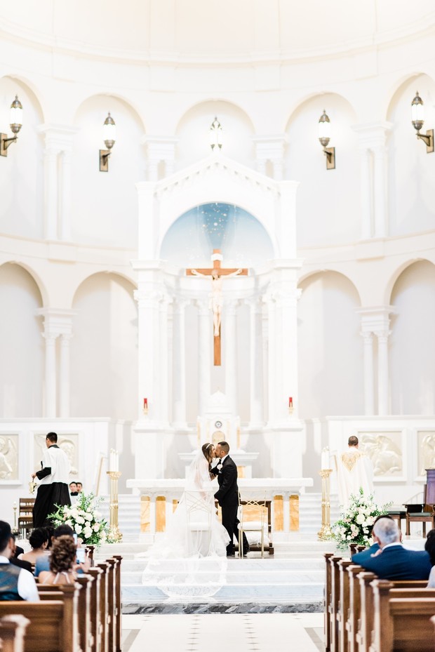 Bride and groom share their first kiss at a church wedding