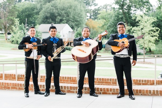 Mariachi band in formal attire playing various instruments
