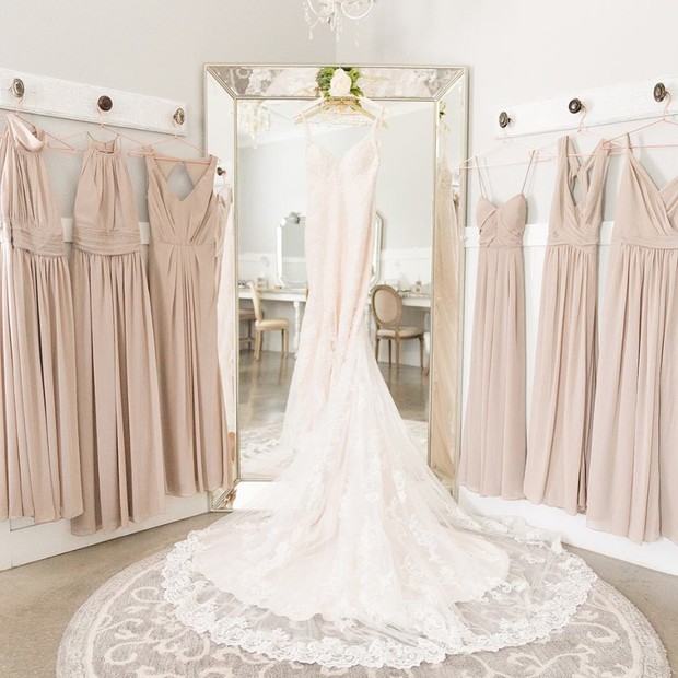 Elegant bridal gown surrounded by bridesmaid dresses in a boutique