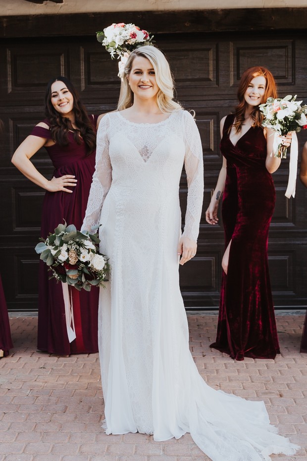 Bride in long white gown with bridesmaids in burgundy dresses
