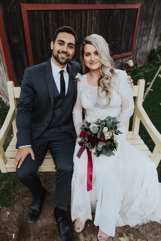 Happy couple smiles on swing on their wedding day
