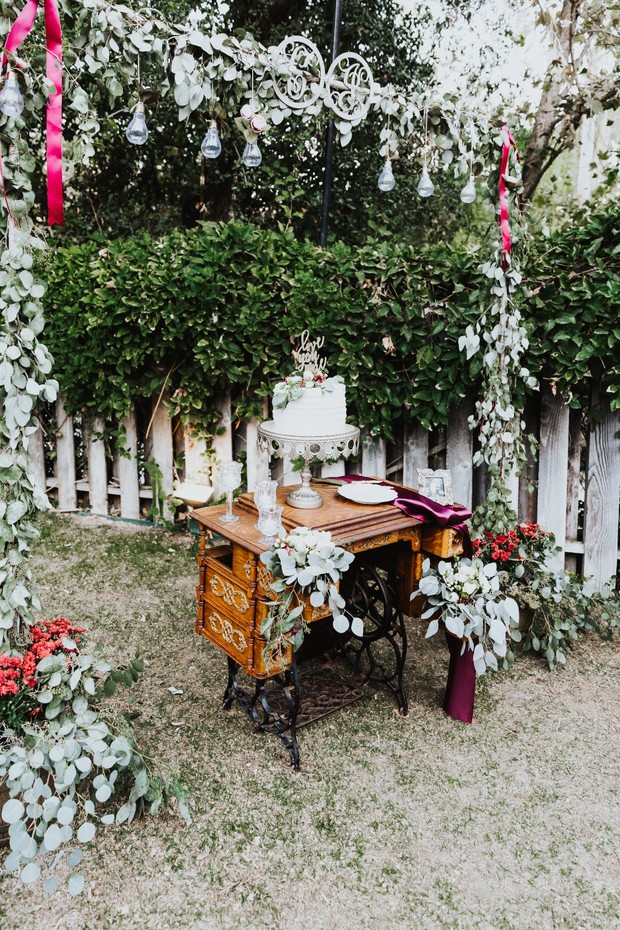 Wedding cake on antique sewing machine table with decorations