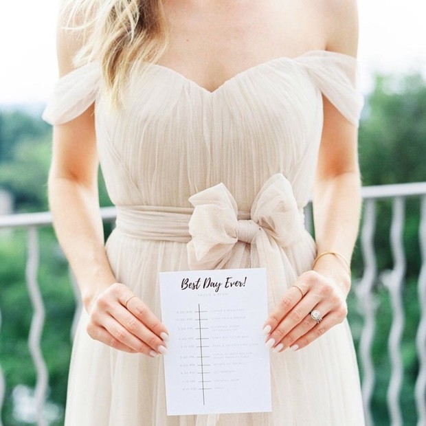 Bride in off-the-shoulder gown holds Best Day Ever card