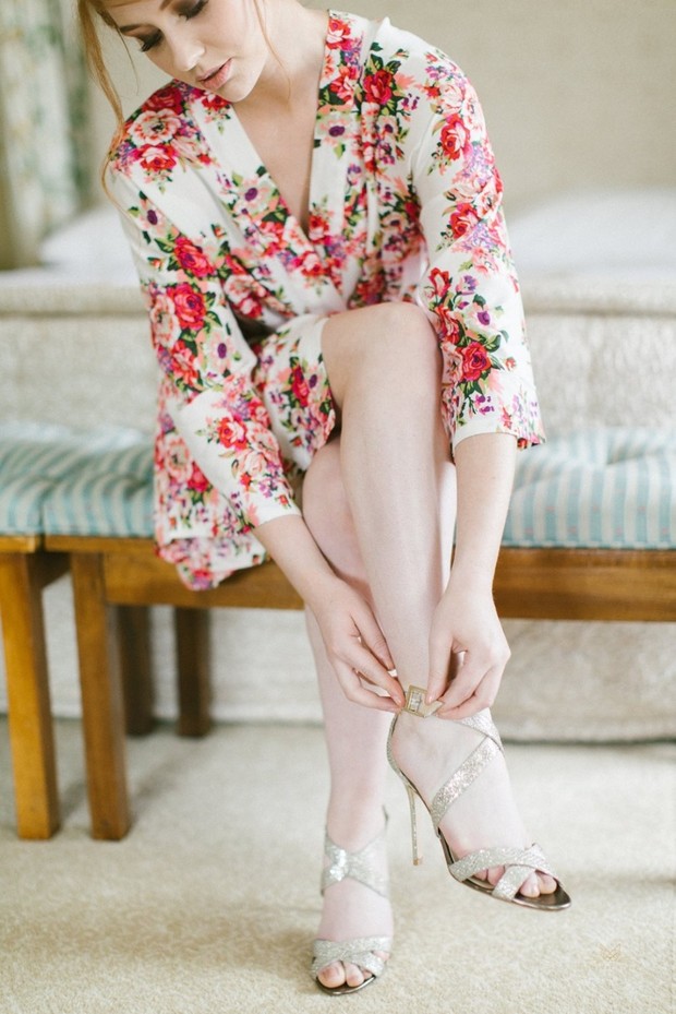 Bride in floral robe puts on sparkly heels