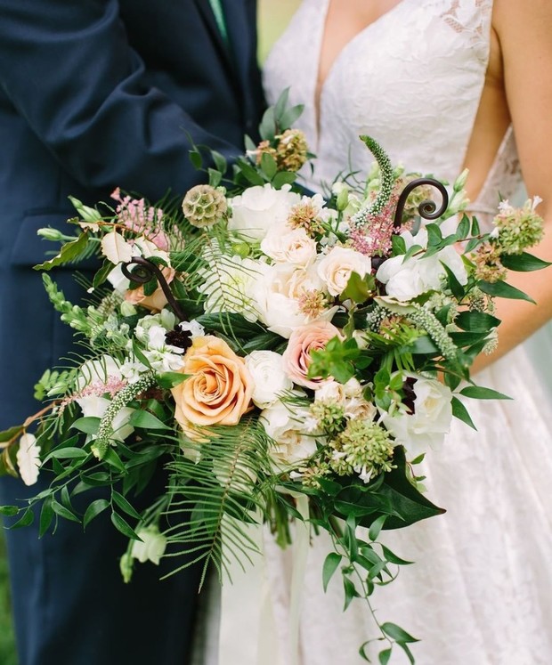 Stunning peach and white wedding bouquet with lush greenery