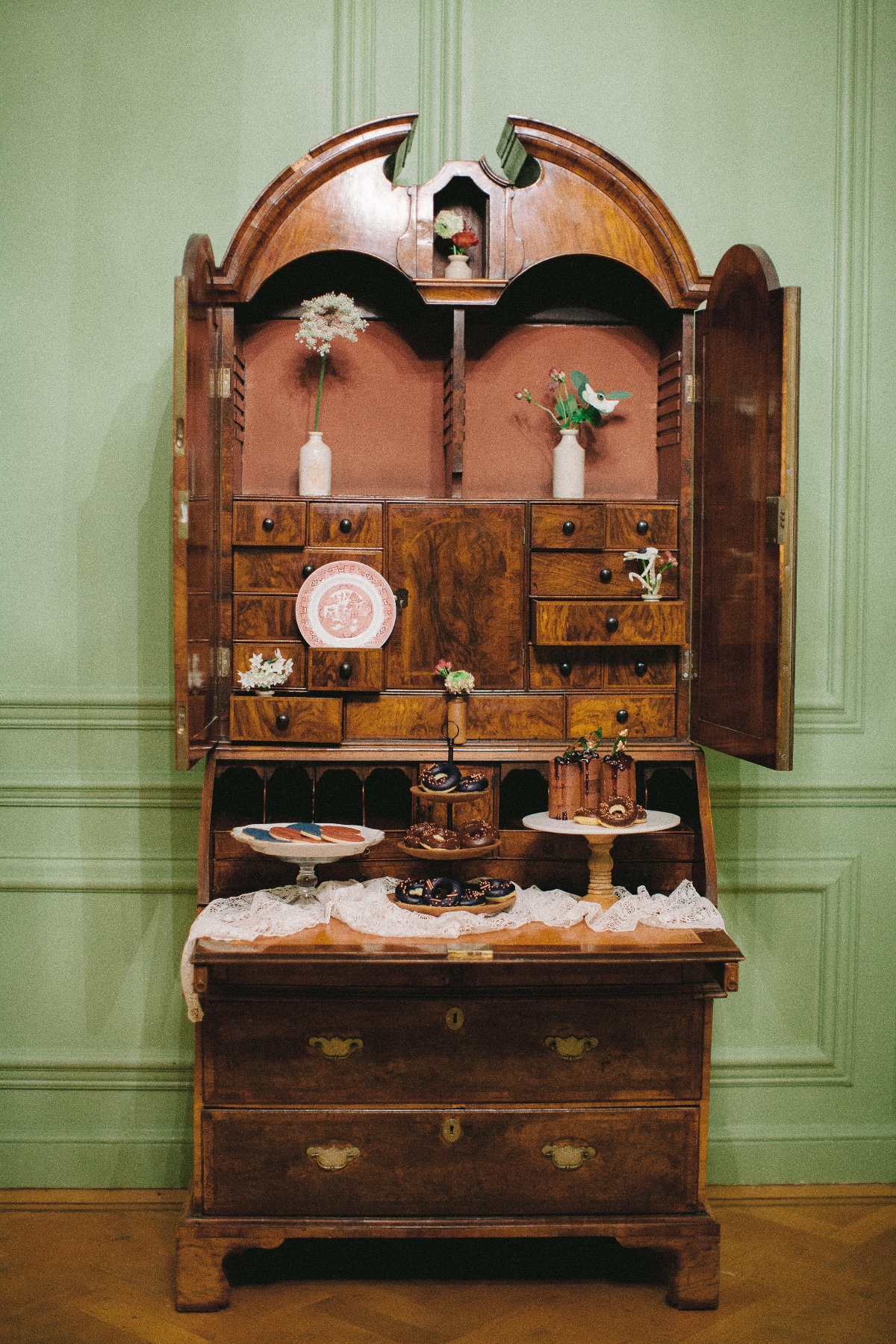 Antique secretary desk with desserts and flowers