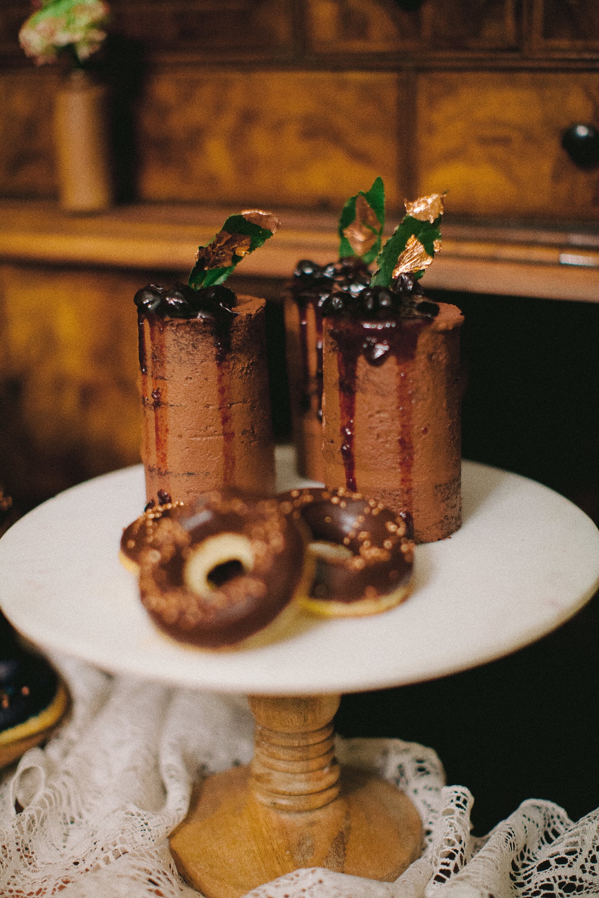 Chocolate cakes with berries and donuts on cake stand