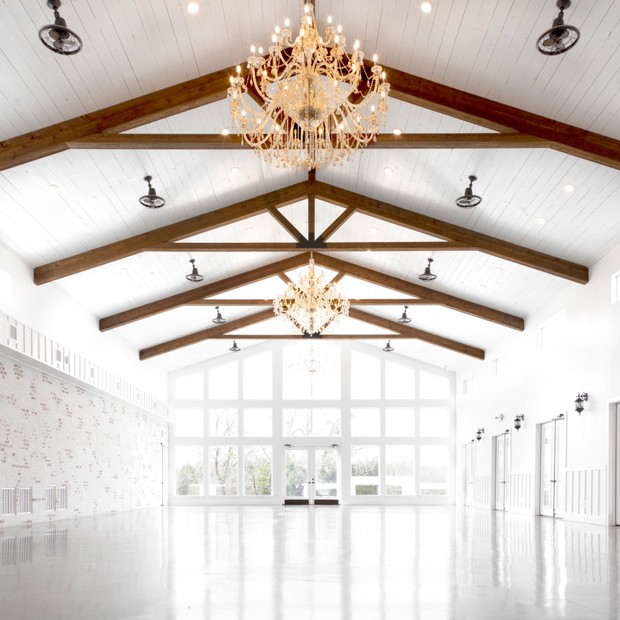 Elegant empty event hall with crystal chandeliers and wooden beams