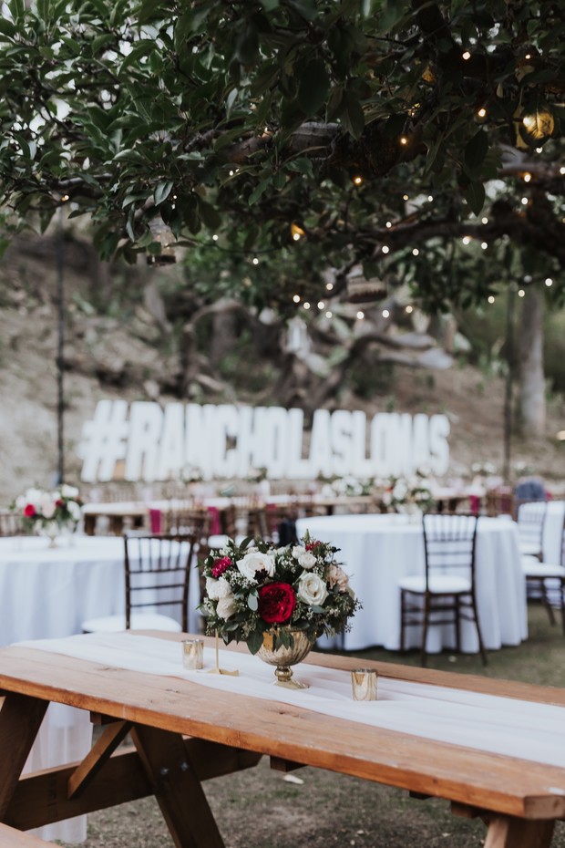Outdoor wedding reception with floral arrangement and table setting