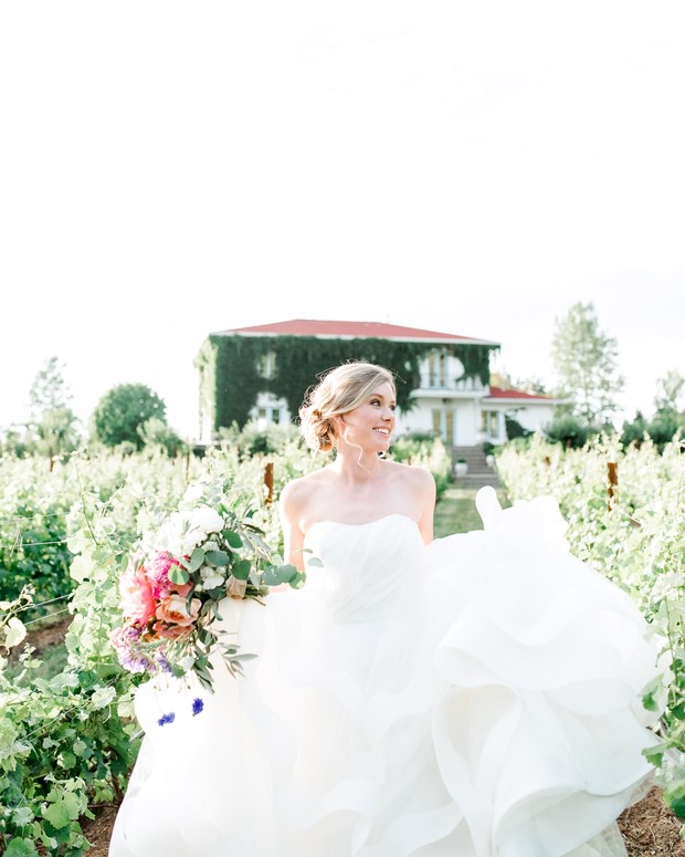 Beautiful bride in a vineyard wedding dress with bouquet