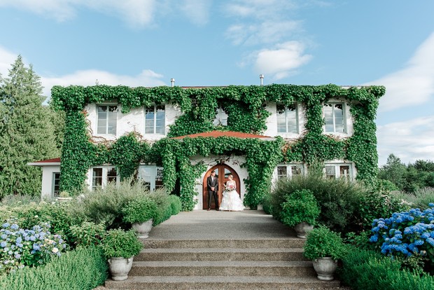 Bride and groom at ivy covered wedding venue entrance