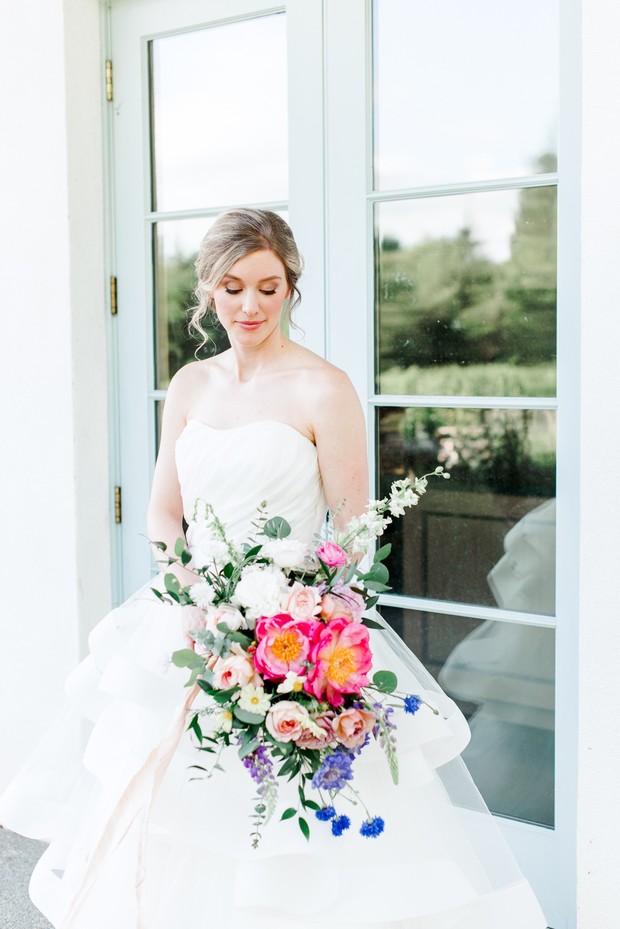 Elegant bride holding colorful peony wedding bouquet