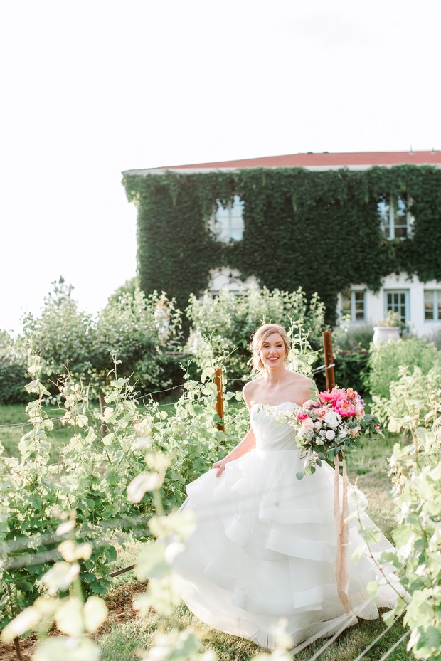 Happy bride in white dress at vineyard wedding venue