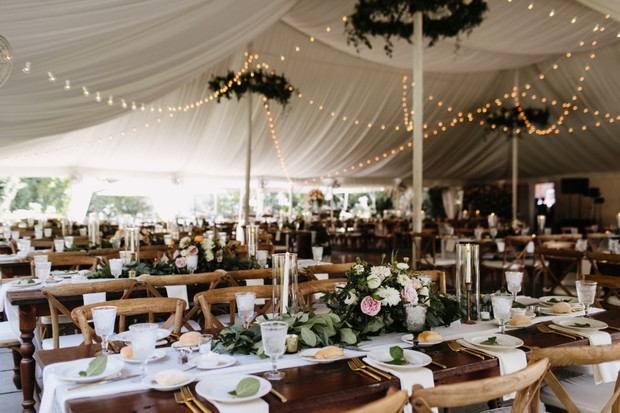 Elegant tented wedding reception with floral centerpieces