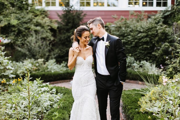 Bride and groom embrace in lush garden wedding venue