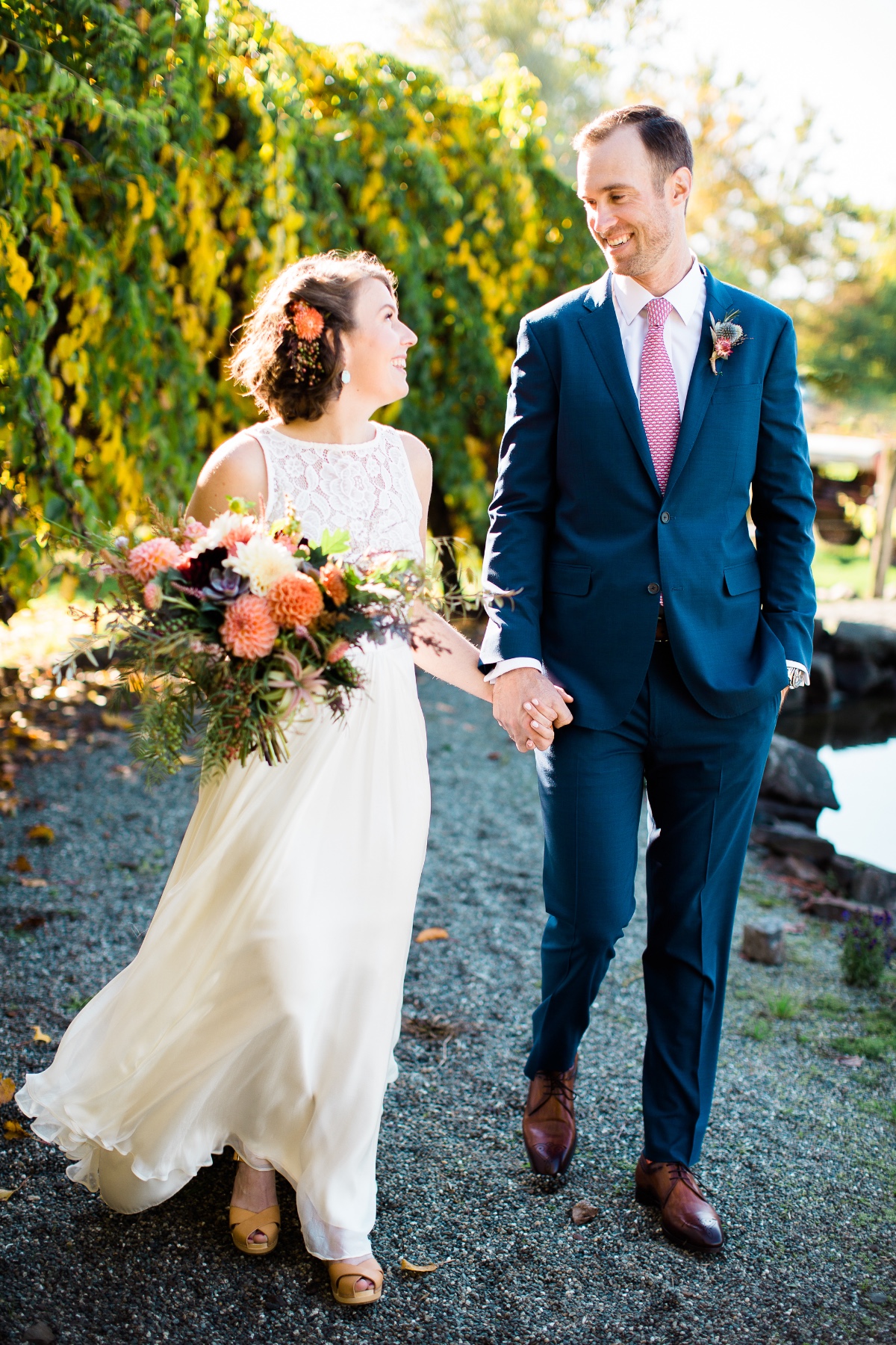 Newlyweds holding hands smiling outdoors on wedding day