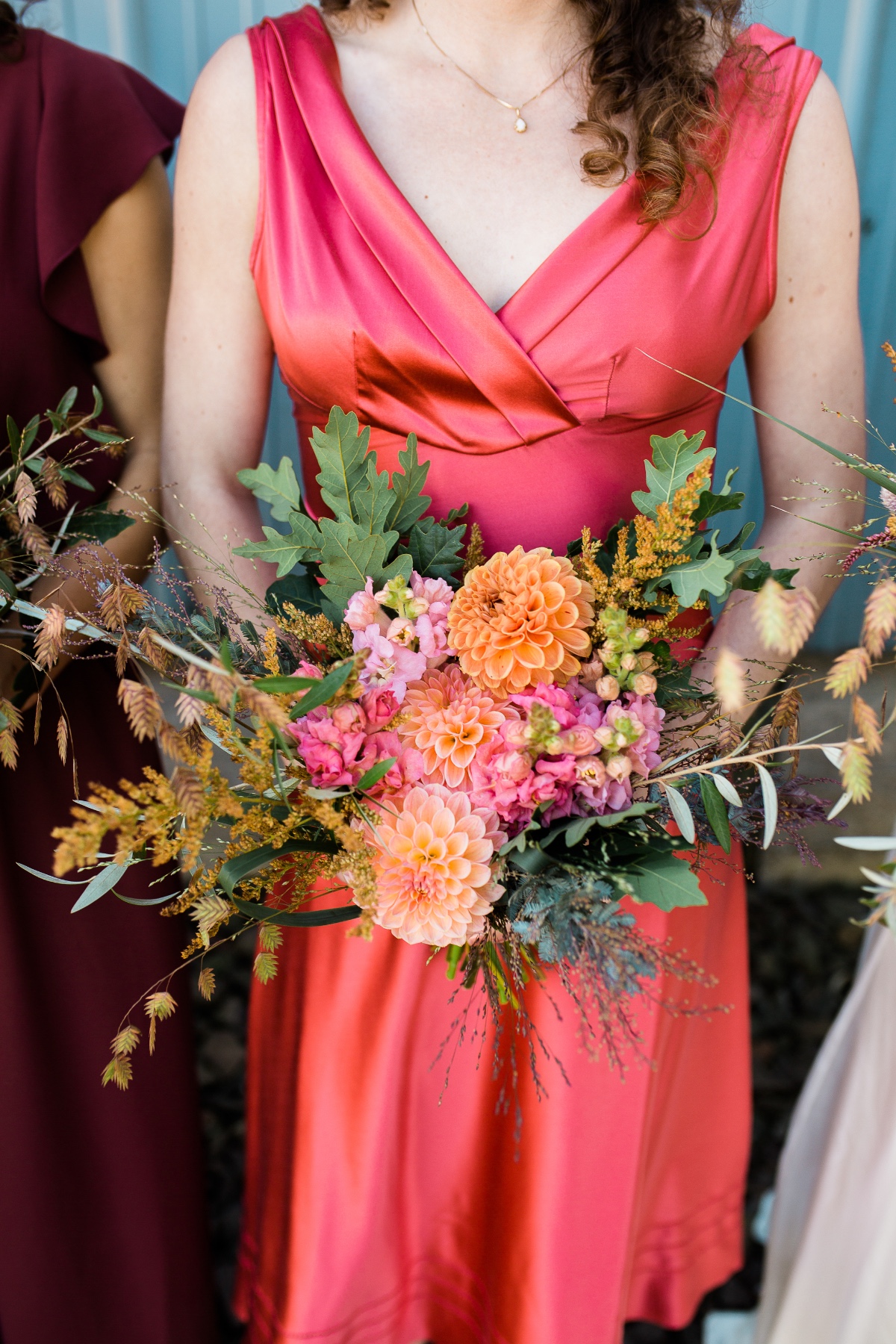 Bridesmaid in pink dress with peach dahlia bouquet
