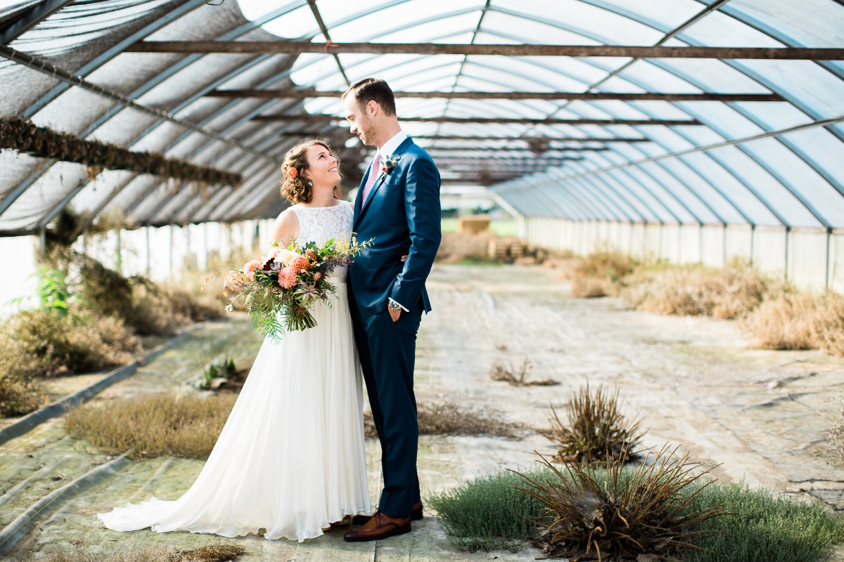 Happy couple posing in a greenhouse for wedding photo