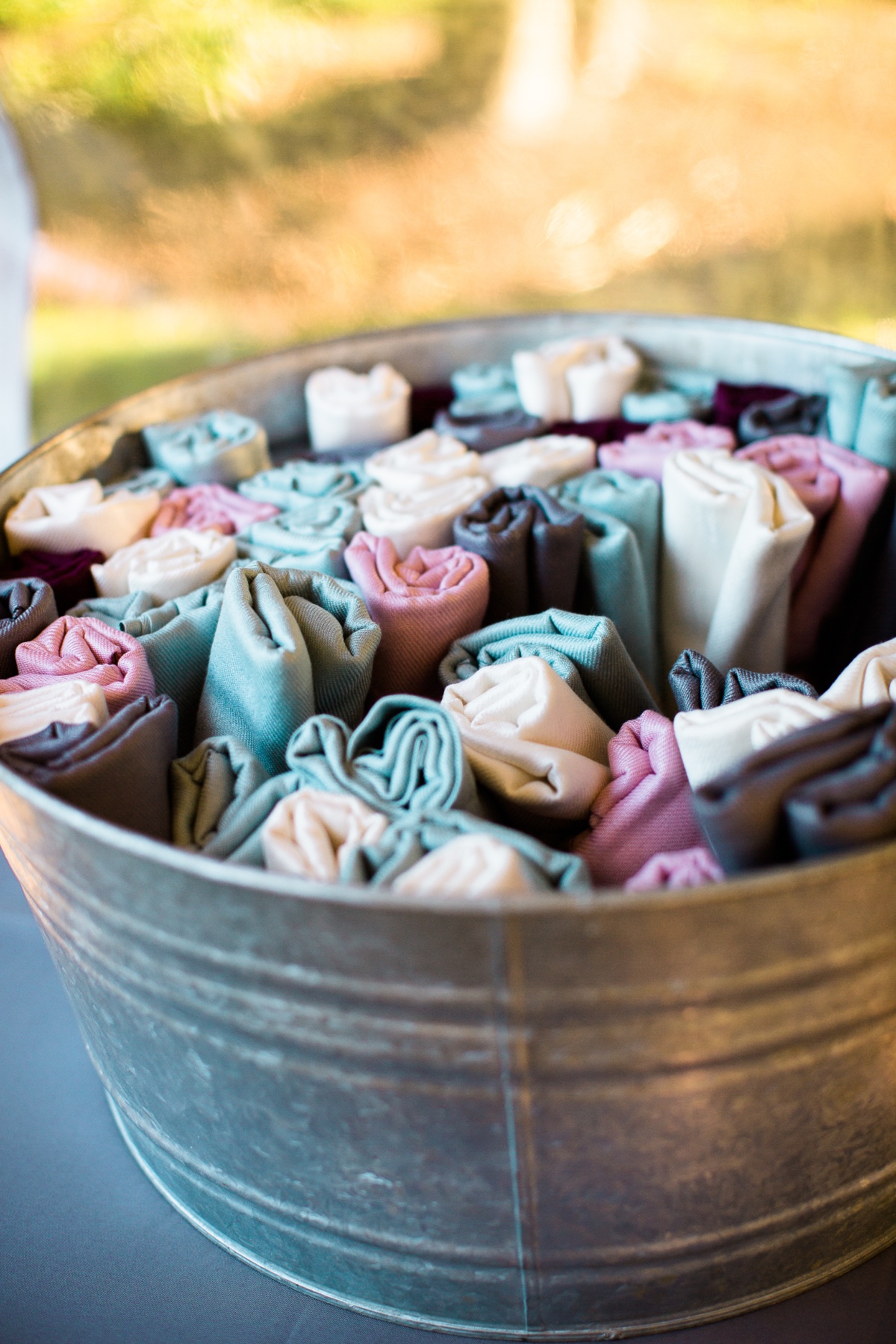 Rolled pastel towels in galvanized tub for event decor