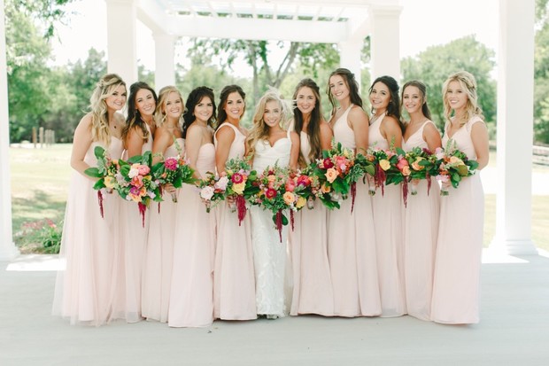 Beautiful bride and bridesmaids with colorful flower bouquets