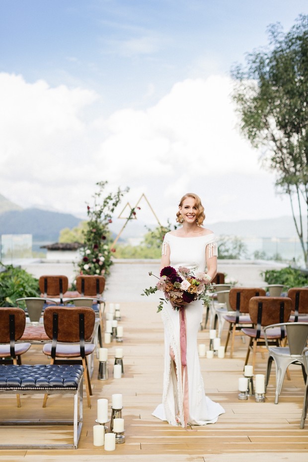 Bride with bouquet at outdoor wedding ceremony setup