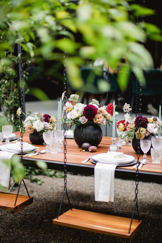 Outdoor swing table setting with floral centerpieces
